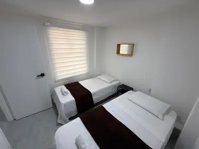a small room with two beds and a window at Cómodo Family Laureles-Estadio 4BR cerca la 70 maximo 10 personas in Medellín
