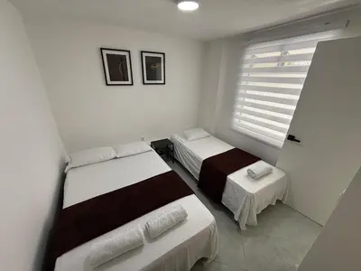 a bedroom with two beds and a window at Cómodo Family Laureles-Estadio 4BR cerca la 70 maximo 10 personas in Medellín