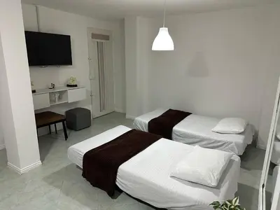 a hotel room with two beds and a flat screen tv at Cómodo Family Laureles-Estadio 4BR cerca la 70 maximo 10 personas in Medellín