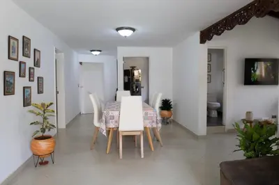 a dining room with a white table and chairs at Casa amplia y acogedora en el corazón de Laureles in Medellín