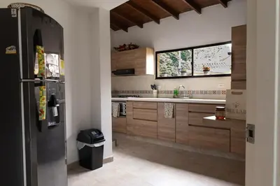a kitchen with a black refrigerator and a window at Casa amplia y acogedora en el corazón de Laureles in Medellín