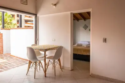 a dining room with a table and chairs and a bed at Casa amplia y acogedora en el corazón de Laureles in Medellín