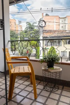 a yellow chair and a plant on a balcony at Casa amplia y acogedora en el corazón de Laureles in Medellín