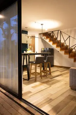 a dining room and kitchen with a table and a staircase at Nomadic Suites in Medellín