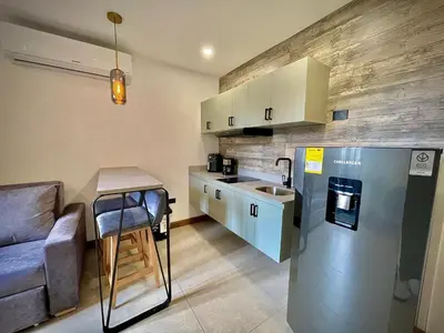 a small kitchen with a refrigerator and a sink at Nomadic Suites in Medellín