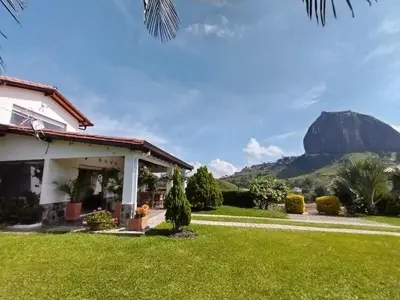 a house with a mountain in the background at Increíble villa de lujo, vistas espectaculares in Guatapé