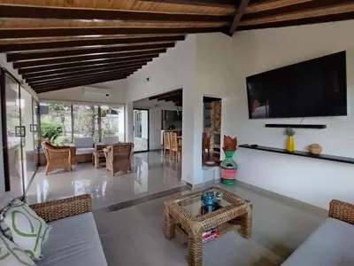 a living room with a couch and a tv on the wall at Increíble villa de lujo, vistas espectaculares in Guatapé
