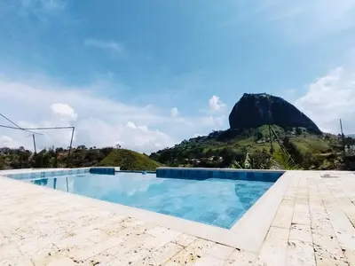 a swimming pool with a mountain in the background at Increíble villa de lujo, vistas espectaculares in Guatapé