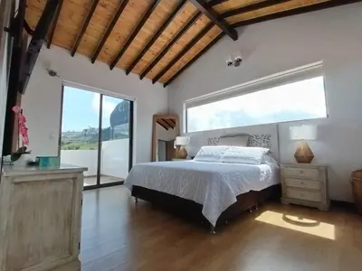 a bedroom with a bed and a large window at Increíble villa de lujo, vistas espectaculares in Guatapé