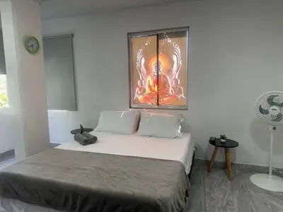 a bedroom with a bed with a painting on the wall at Apartamento días - weeks with kitchen in Santa Fe de Antioquia