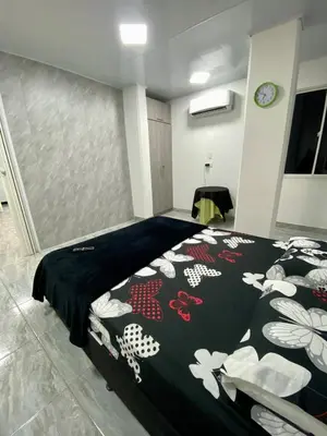 a bedroom with a bed with a black comforter at Apartamento días - weeks with kitchen in Santa Fe de Antioquia
