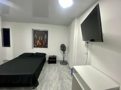 a bedroom with a bed and a flat screen tv at Apartamento días - weeks with kitchen in Santa Fe de Antioquia