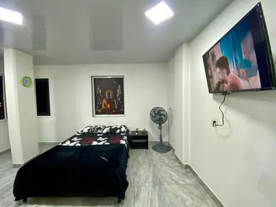 a bedroom with a bed and a flat screen tv at Apartamento días - weeks with kitchen in Santa Fe de Antioquia