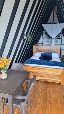 a small bedroom with a bed and a table at Glamping Arcoiris in Ciudad Bolívar