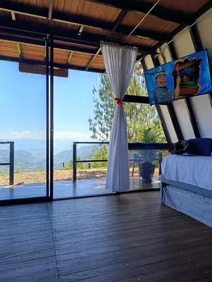 a bedroom with a bed and a view of the mountains at Glamping Arcoiris in Ciudad Bolívar