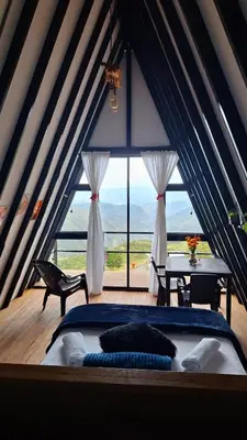 a bedroom with a bed and a large window at Glamping Arcoiris in Ciudad Bolívar