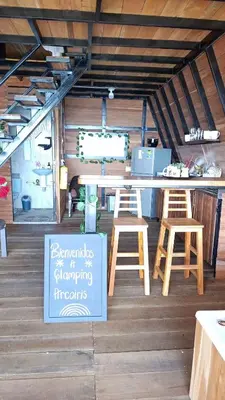 a table and two stools and a sign in a room at Glamping arcoiris r in Ciudad Bolívar