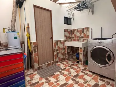 a laundry room with a washing machine and a door at Apartamento en Belen cerca a Laureles, wifi, Balcon y Patio in Medellín