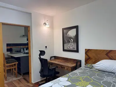 a bedroom with a bed and a desk and a deskablish at Apartamento en Belen cerca a Laureles, wifi, Balcon y Patio in Medellín