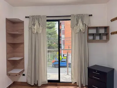 a room with a sliding glass door with curtains at Apartamento en Belen cerca a Laureles, wifi, Balcon y Patio in Medellín