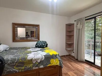 a bedroom with a bed and a mirror and a window at Apartamento en Belen cerca a Laureles, wifi, Balcon y Patio in Medellín