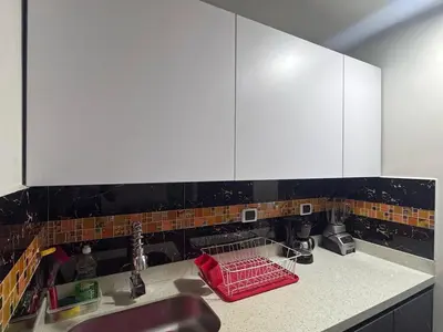 a kitchen counter with a sink and white cabinets at Apartamento en Belen cerca a Laureles, wifi, Balcon y Patio in Medellín