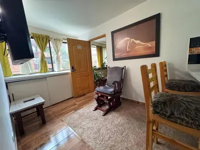 a living room with a chair and a bed at Apartamento en Belen cerca a Laureles, wifi, Balcon y Patio in Medellín