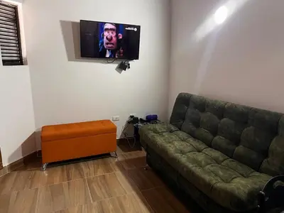 a living room with a couch and a flat screen tv at Bombona Apartment in Medellín