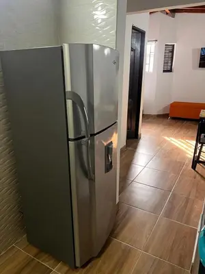 a stainless steel refrigerator sitting in a room at Bombona Apartment in Medellín