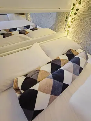 a row of beds with pillows and a blanket at Apartamento en concepción entorno natural in Concepción