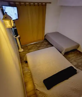 a small room with two beds and a window at Moderno y acogedor departamento in Concepción