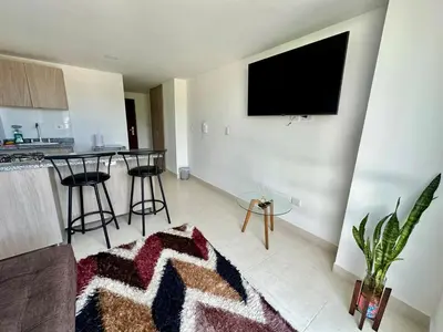 a living room with a flat screen tv on a wall at Lindo Apto central Urban Mzles in Manizales