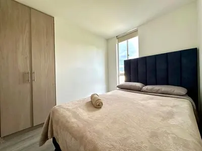 a bedroom with a large bed with a blue headboard at Lindo Apto central Urban Mzles in Manizales