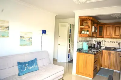a living room with a couch and a kitchen at Comodo apartamento 2-2 - Parqueo cubierto para 1 carro - En el corazón de Guatape in Guatapé