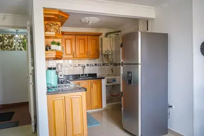 a kitchen with wooden cabinets and a stainless steel refrigerator at Comodo apartamento 2-2 - Parqueo cubierto para 1 carro - En el corazón de Guatape in Guatapé