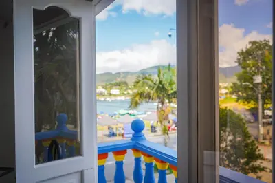 a window with a view of a beach and the ocean at Comodo apartamento 2-2 - Parqueo cubierto para 1 carro - En el corazón de Guatape in Guatapé