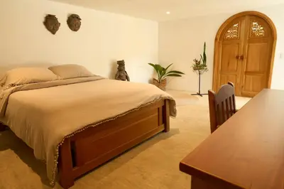 a bedroom with a large bed and a wooden table at Villa Talataa in Tarso