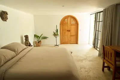 a bedroom with a large bed and a wooden door at Villa Talataa in Tarso
