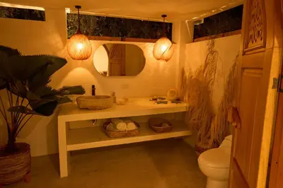 a bathroom with a sink and a toilet and a mirror at Villa Talataa in Tarso