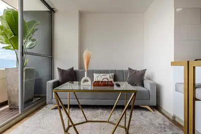 a living room with a couch and a glass table at 15minPOBLADO-LUXURY-Sabaneta in Sabaneta