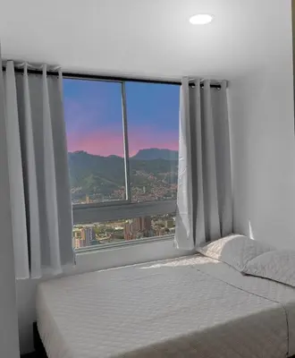 a bedroom with a bed and a large window at 15minPOBLADO-LUXURY-Sabaneta in Sabaneta