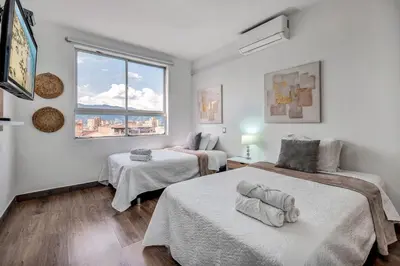 a bedroom with two beds and a window at Luxury Penthouse Con Aire acondicionado in Envigado