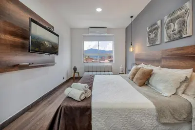 a bedroom with a large bed and a flat screen tv at Luxury Penthouse Con Aire acondicionado in Envigado
