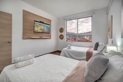 a bedroom with two beds and a window at Luxury Penthouse Con Aire acondicionado in Envigado