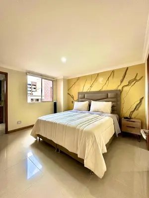 a bedroom with a large bed with a branch wall at Beautiful Laureles apartment in Medellín