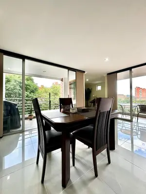 a dining room with a wooden table and chairs at Beautiful Laureles apartment in Medellín