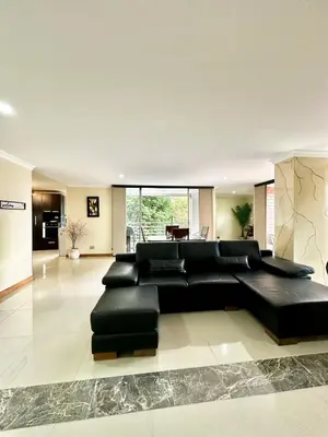 a living room with a large black leather couch at Beautiful Laureles apartment in Medellín