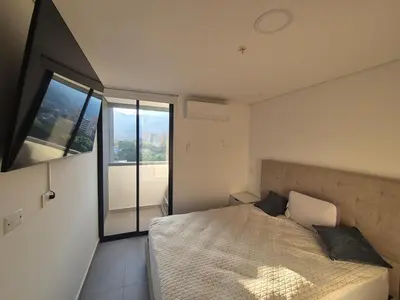 a bedroom with a bed and a large window at Laureles 11th Floor, Jacuzzi and AC in Medellín