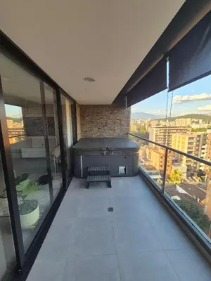 a balcony with a hot tub in a building with windows at Laureles 11th Floor, Jacuzzi and AC in Medellín