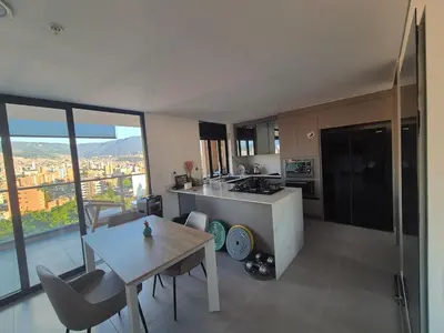 a kitchen with a table and a kitchen with a view at Laureles 11th Floor, Jacuzzi and AC in Medellín